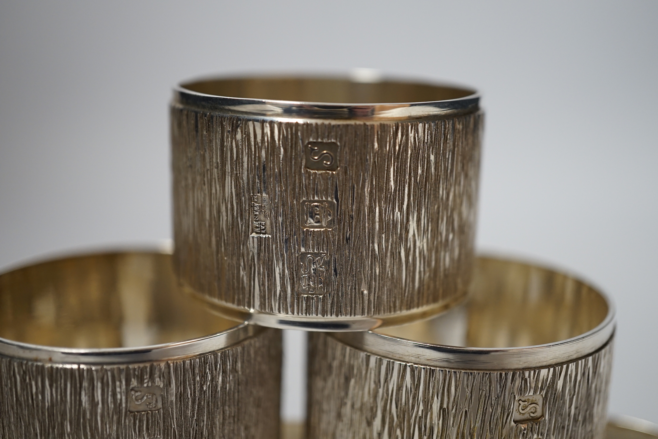 A set of six Elizabeth II textured silver napkin rings, Mappin & Webb, London, 1973, 46mm, 10.9oz, with Mappin & Webb box.